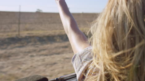beautiful-blonde-friend-enjoying-road-trip-in-vintage-convertible-car