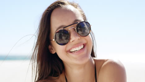 Close-up-portrait-of-beautiful-young-woman-smiling-on-tropical-beach-slow-motion