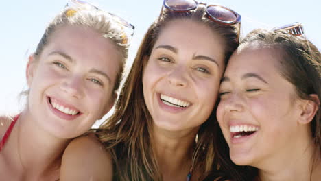 Close-up-portrait-of-three-teenage-girl-friends-smiling-on-tropical-beach-slow-motion