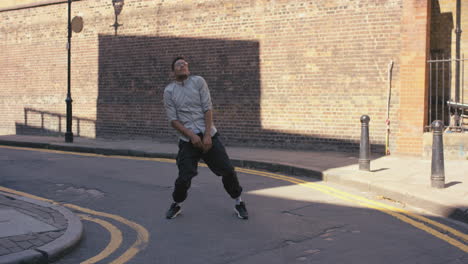 Contemporary-funky-mixed-race-man-street-dancer-dancing-freestyle-in-the-city
