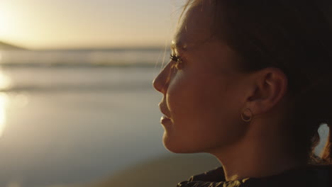 close-up-portrait-of-beautiful-young-woman-enjoying-calm-peaceful-sunset-looking-relaxed-pensive-caucasian-female-on-ocean-seaside-beach
