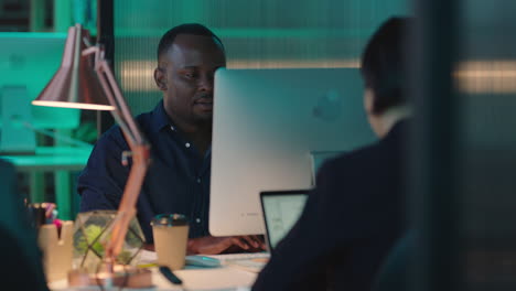 young-african-american-businessman-working-late-using-computer-looking-tired-stressed-black-entrepreneur-in-office-workspace