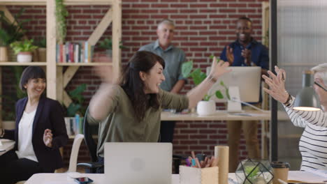young-business-woman-arms-raised-celebrating-surprise-corporate-success-laughing-cheerful-enjoying-colleagues-cheering-in-office-workspace