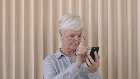 Porträt-Einer-Schönen-älteren-Frau-Im-Ruhestand,-Die-SMS-Schreibt-Und-Mit-Dem-Smartphone-Surft-Seniorin-Mit-Sehproblemen