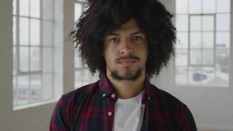 portrait-of-young-mixed-race-man-looking-seriousat-camera-independent-student-lifestyle-in-apartment-trendy-afro-hairstyle