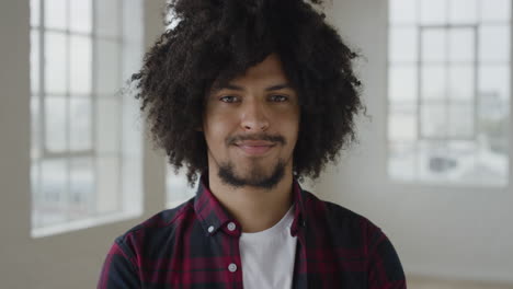 portrait-of-young-mixed-race-student-man-smiling-happy-looking-at-camera-enjoying-independent-lifestyle-in-apartment-trendy-afro-hairstyle-slow-motion