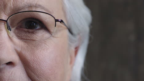 close-up-half-face-of-elderly-woman-eye-opening-looking-at-camera-wearing-glasses