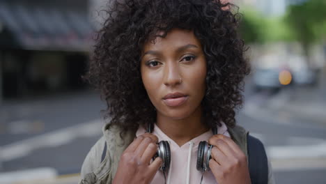 portrait-of-attractive-african-american-woman-looking-calm-pensive-at-camera-young-black-female-student-in-urban-city-background-real-people-series