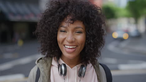 Retrato-De-Una-Mujer-Afroamericana-Sonriendo-Alegre-Disfrutando-De-La-Satisfacción-Del-Estilo-De-Vida-Urbano-Joven-Estudiante-Negra-En-El-Fondo-De-La-Calle-De-La-Ciudad-Serie-De-Personas-Reales