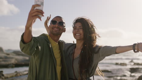 cheerful-happy-mixed-race-couple-posing-for-selfie-at-beach