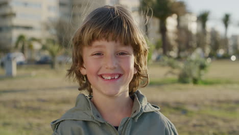 portrait-of-cute-happy-boy-smiling-cheerful-at-camera-enjoying-fun-day-on-seaside-park