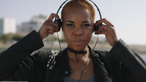 portait-of-young-african-american-woman-on-sunny-beachfront-puts-on-headphones-listening-to-music