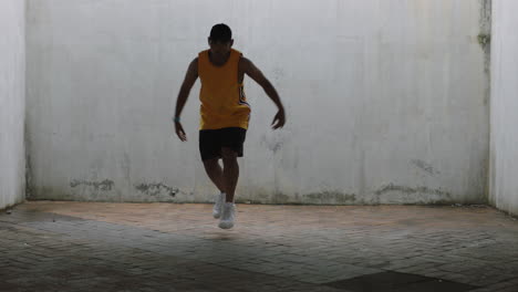 dancing-man-young-happy-street-dancer-performing-various-freestyle-dance-moves-fit-mixed-race-male-practicing-in-grungy-warehouse-wearing-yellow-vest