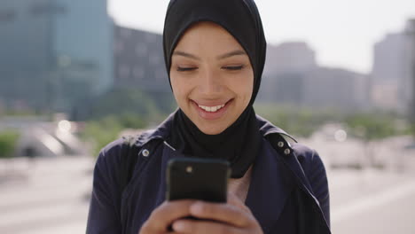 slow-motion-portrait-of-beautiful-mixed-race-muslim-woman-enjoying-using-smartphone-social-media-app-texting-in-urba-ncity-background