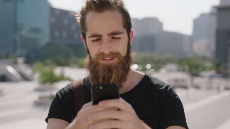 slow-motion-portrait-of-handsome-young-hipster-man-student-with-beard-enjoying-texting-browsing-using-smartphone-social-media-app-in-urban-background