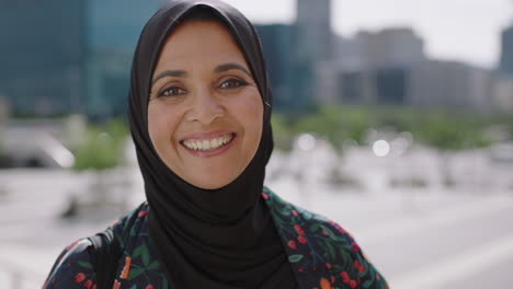 close-up-portrait-of-beautiful-mature-muslim-woman-smiling-friendly-at-camera-in-sunny-urban-city-wearing-traditional-headscarf