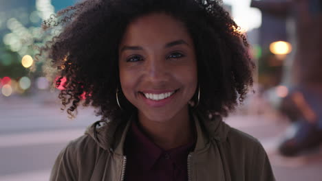 Porträt-Einer-Stilvollen-Jungen-Schwarzen-Frau-Mit-Afro,-Die-Glücklich-In-Die-Kamera-Lächelt-Und-Das-Nachtleben-In-Der-Stadt-Genießt