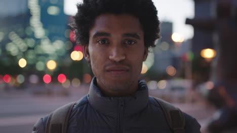 portrait-of-charming-young-mixed-race-man-looking-pensive-at-camera-serious-male-in-urban-evening-background