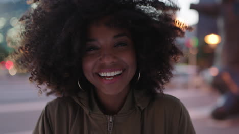 portrait-of-stylish-young-black-woman-with-afro-laughing-playful-enjoying-night-life-in-city-wind-blowing-hair-urban-lifestyle