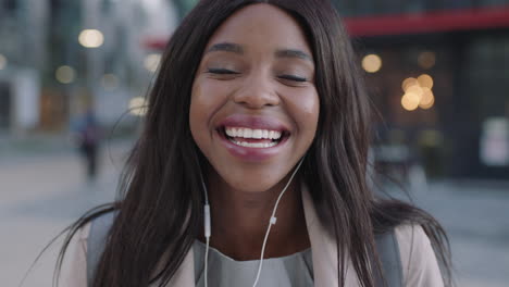 portrait-of-successful-african-american-woman-laughing-downtown-earphones-listening-to-music