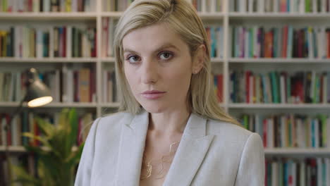 portrait-of-attractive-blonde-business-woman-looking-serious-at-camera-wearing-stylish-suit-in-library-office-background