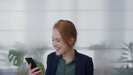 portrait-young-happy-red-head-business-woman-using-smartphone-video-chatting-blow-kiss-enjoying-mobile-phone-communication-laughing-cheerful-slow-motion