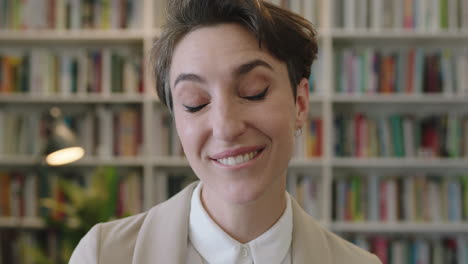 close-up-portrait-of-young-professional-business-woman-enjoying-silly-fun-making-faces-spontaneous-female-wearing-stylish-suit-in-library-office-background