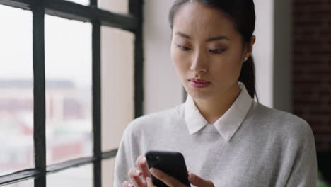 Schöne-Asiatische-Geschäftsfrau,-Die-Zu-Hause-Ihr-Smartphone-Nutzt,-Nachrichten-Durchstöbert-Und-Auf-Dem-Mobiltelefon-SMS-Schreibt,-Und-Dabei-Entspanntes-Networking-Am-Morgen-Genießt