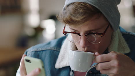 stylish-hipster-man-student-using-smartphone-in-cafe-browsing-online-social-media-messages-enjoying-drinking-coffee-sharing-lifestyle-reading-mobile-phone-sms-communication