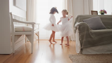 happy-little-ballerina-girls-practicing-ballet-dance-wearing-tutu-sisters-playing-pretend-game-at-home-enjoying-childhood-imagination-4k-footage