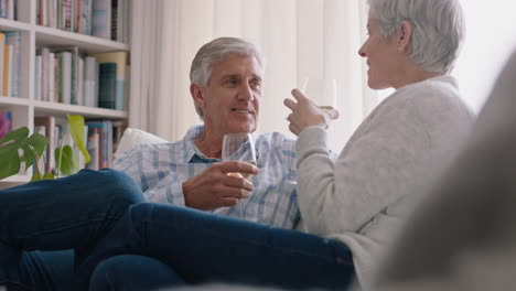 Glückliches-Altes-Paar,-Das-Wein-Trinkt,-Sich-Zu-Hause-Auf-Dem-Sofa-Entspannt-Und-Toast-Macht,-Jubiläum-Feiert-Und-Eine-Romantische-Beziehung-Auf-Bequemen-4K-Videos-Im-Ruhestand-Genießt