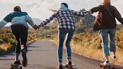 young-multi-ethnic-friends-longboarding-together-holding-hands-riding-skateboard-cruising-downhill-on-countryside-road-having-fun-enjoying-relaxed-summer-vacation