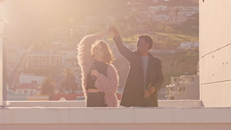 happy-young-multiracial-couple-dancing-on-rooftop-at-sunset-celebrating-relationship-having-fun-enjoying-playful-dance-together
