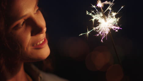 close-up-sparklers-portrait-of-attractive-woman-celebrating-new-years-eve-enjoying-independence-day-celebration-having-fun-at-night