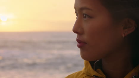 portrait-of-happy-asian-woman-enjoying-peaceful-contemplation-exploring-carefree-lifestyle-relaxing-on-beach-feeling-positive-at-sunrise