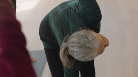 Clase-De-Yoga-Hermosa-Anciana-Practicando-Pose-Traingle-Disfrutando-De-Un-Estilo-De-Vida-Saludable-Meditación-Grupal-En-El-Gimnasio