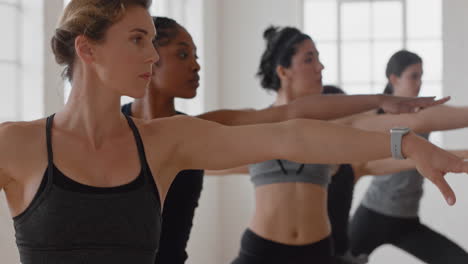 Yoga-Kursgruppe-Gemischtrassiger-Frauen,-Die-Kriegerpose-Praktizieren-Und-Einen-Gesunden-Lebensstil-Genießen-Und-Im-Fitnessstudio-Trainieren