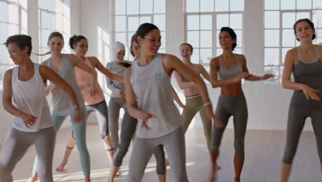 Grupo-De-Mujeres-Multiétnicas-Aprendiendo-Movimientos-De-Baile-Disfrutando-De-Un-Instructor-De-Fitness-Enseñando-Coreografía-De-Baile-Mostrando-Rutina-Divirtiéndose-En-El-Estudio