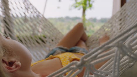young-woman-in-hammock-swaying-peacefully-on-lazy-summer-day-enjoying-vacation-lifestyle-at-holiday-resort