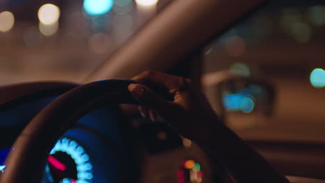 woman-driving-car-with-hands-on-steering-wheel-in-city-at-night-travelling-on-the-road-to-destination