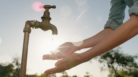 farmer-woman-washing-hands-under-tap-on-rural-farm-freshwater-flowing-from-faucet-with-afternoon-sun-flare