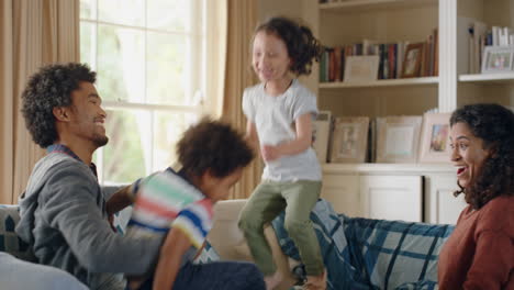 Niños-Felices-Saltando-En-El-Sofá-Disfrutando-Jugando-En-Casa-Divirtiéndose-Juntos-El-Fin-De-Semana-Con-Sus-Padres