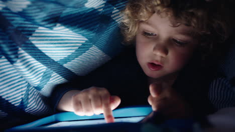 happy-little-boy-using-digital-tablet-computer-under-blanket-enjoying-learning-on-touchscreen-technology-playing-games-having-fun-at-bedtime