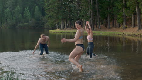 best-friends-jumping-in-lake-at-sunset-taking-off-clothes-splashing-water-enjoying-playful-game-young-people-on-summer-vacation-adventure