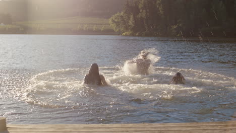 happy-friends-running-jumping-off-jetty-in-lake-at-sunset-having-fun-splashing-in-water-enjoying-freedom-sharing-summertime-adventure