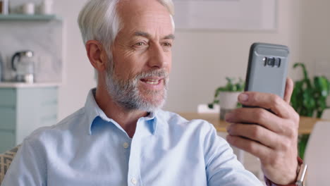 Reifer-Mann,-Der-Mit-Dem-Smartphone-Per-Video-Chat-Chattet-Und-Die-Verbindung-Genießt.-Großvater-Chattet-Zu-Hause-Mit-Dem-Mobiltelefon