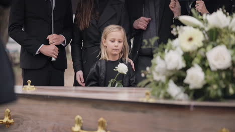 Death,-grief-and-girl-at-funeral-with-flower
