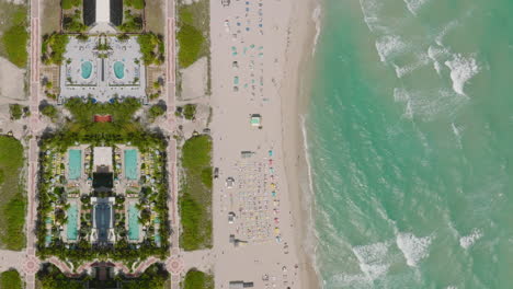 Top-down-footage-of-waves-washing-sand-beach-in-tropical-vacation-resort.-Abstract-computer-effect-digital-composed-footage