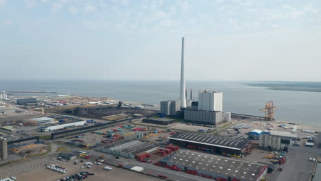 Flight-forward-drone-aerial-view-over-the-power-plant-of-Esbjerg,-Denmark.-The-Steelcon-power-station-chimney-is-the-tallest-in-Scandinavia