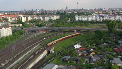 Forwards-fly-above-railway-junction-in-city.-Tracking-S-bahn-train-standing-on-turning-track.-Berlin,-Germany